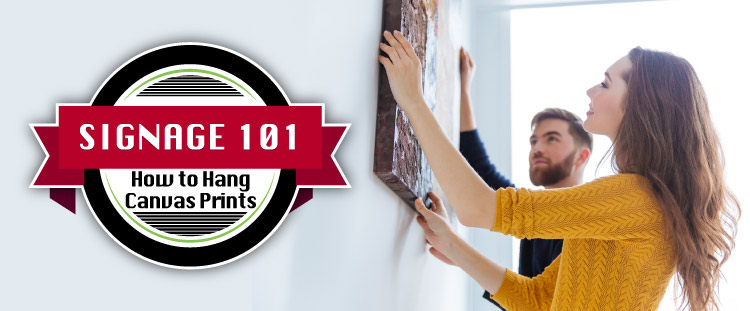 Blog image showing people hanging a canvas on a wall with the blog title.
