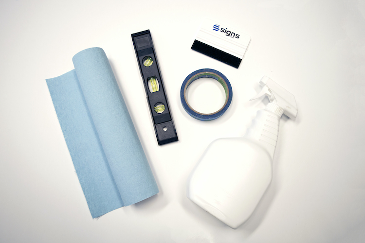 Paper towels, level, painters tape, squeegee and spray bottle